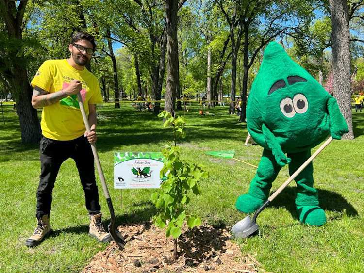 Green Drop Arborist and a Green Drop Trees Care mascot standing by a newly planted tree